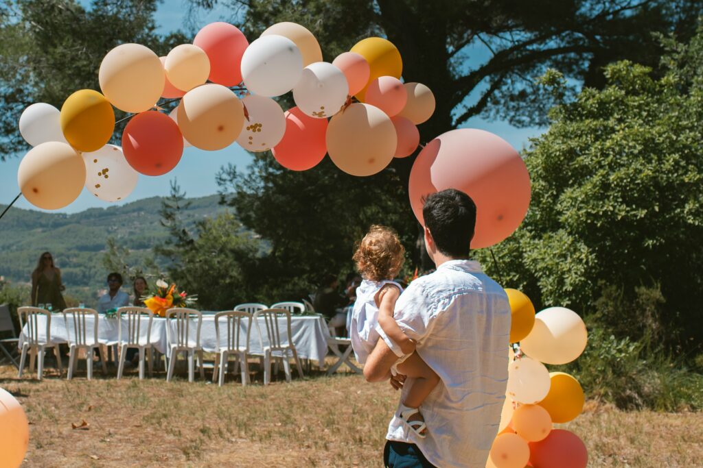 Réception de baptême dans un jardin, ballons et grandes tablées