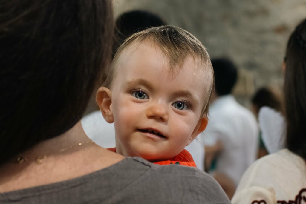 Enfant dans les bras le jour de son baptême