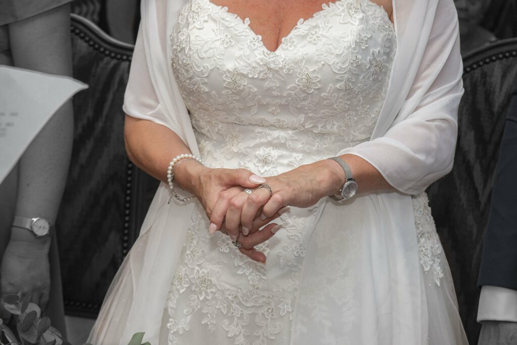 Les mains de la mariée pendant la cérémonie, en noir et blanc